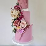 Beautiful dusky pink wrapped three tier wedding cake with floral decoration