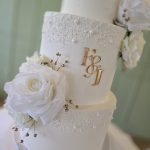 Peral and rose decorated white three tier wedding cake
