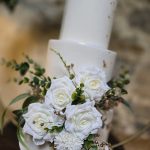 Three tier wedding cake with autumnal floral decoration and gold leaf detail